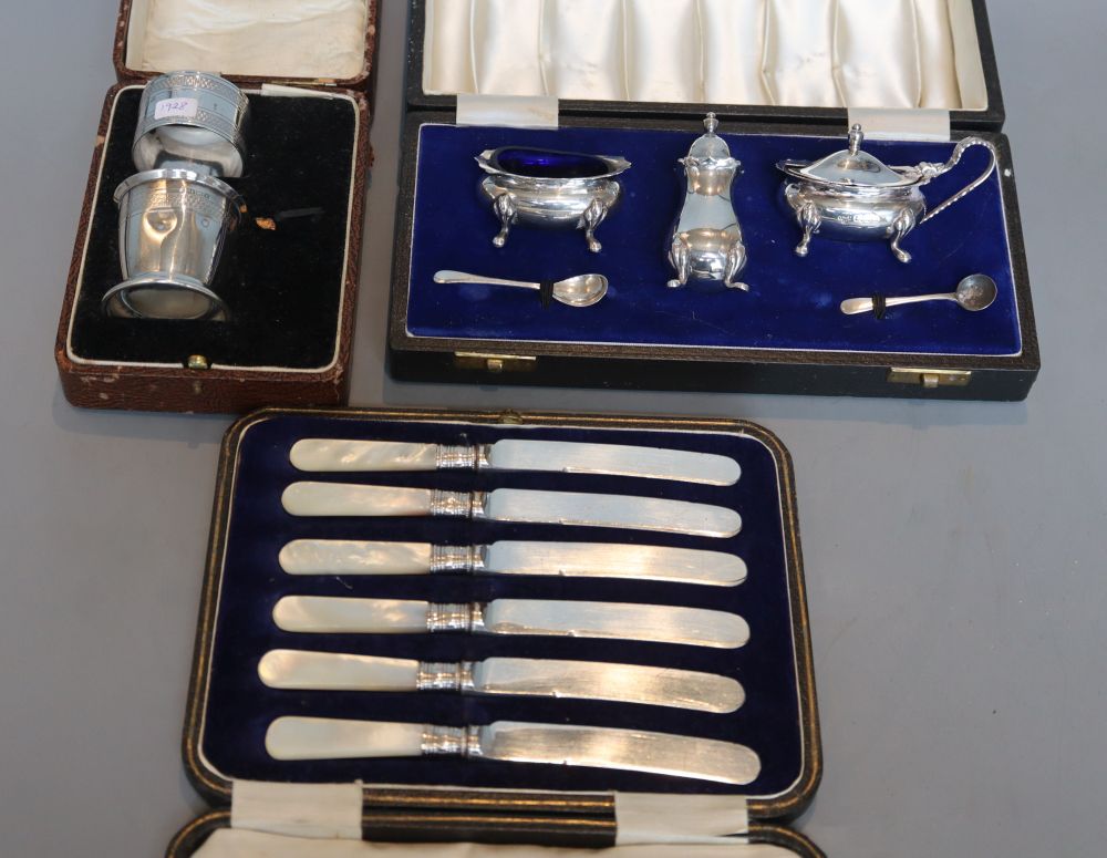 A cased modern three piece silver condiment set, London, 1967, a cased silver part christening set and cased knives.